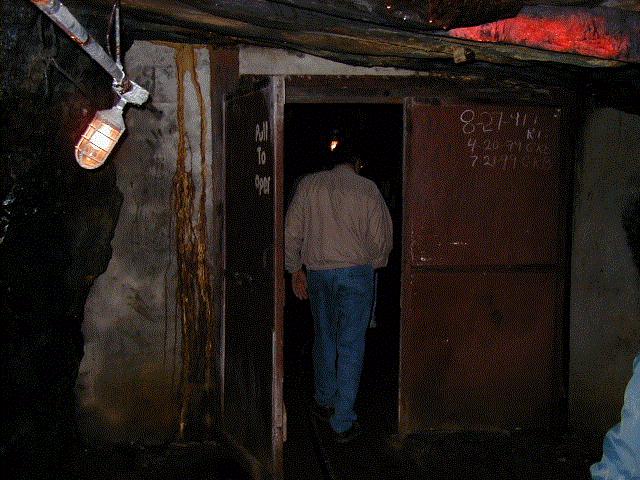 An intrepid visitor enters the airlock through a set of steel doors.