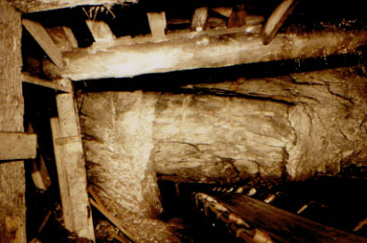 The conveyor belt passes down through a fault. Heavy timbers support the roof.